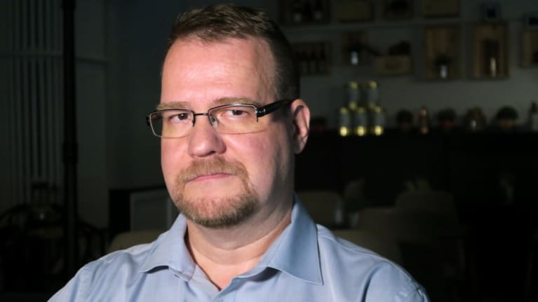 Mies katsoo kameraan