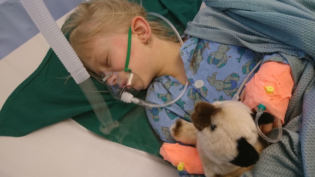 Lapsi sairaalan heräämössä pehmolelun kanssa