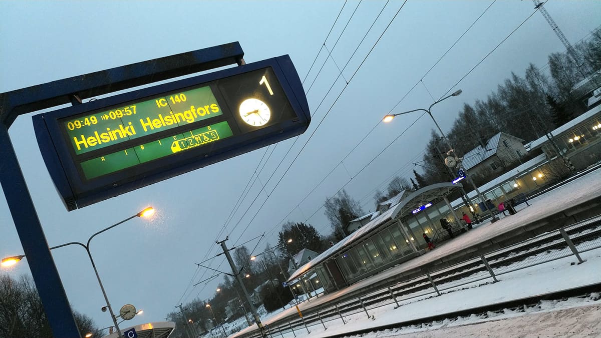 Hämeenlinnan juna-aseman raiteet ja opastaulu, joka kertoo junan olevan myöhässä
