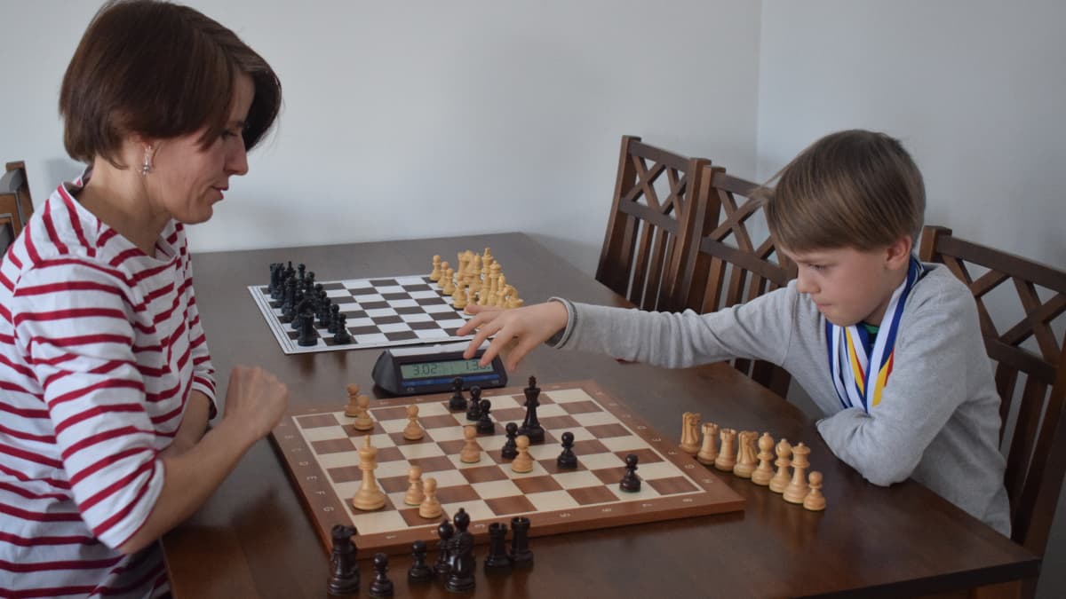 Äiti ja poika pelaavat shakkia
