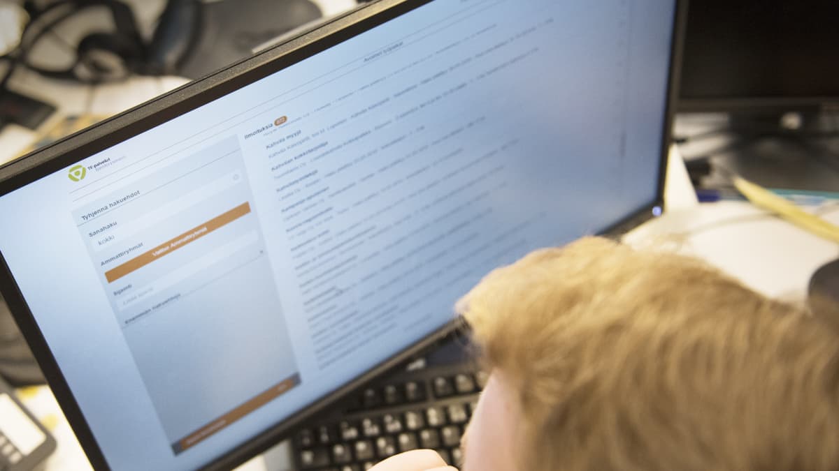 Mies katsoo tietokoneelta vapaita työpaikkoja työvoimatoimiston sivuilta.