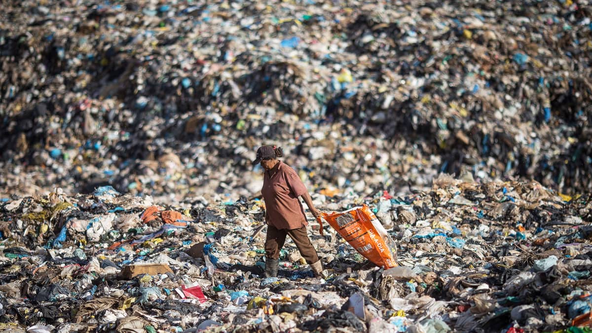 Nainen etsii jätteiden seasta kierrätettäväksi kelpaavia materiaaleja Brasiliassa sijaitsevalla Etelä-Amerikan suurimmalla kaatopaikalla.