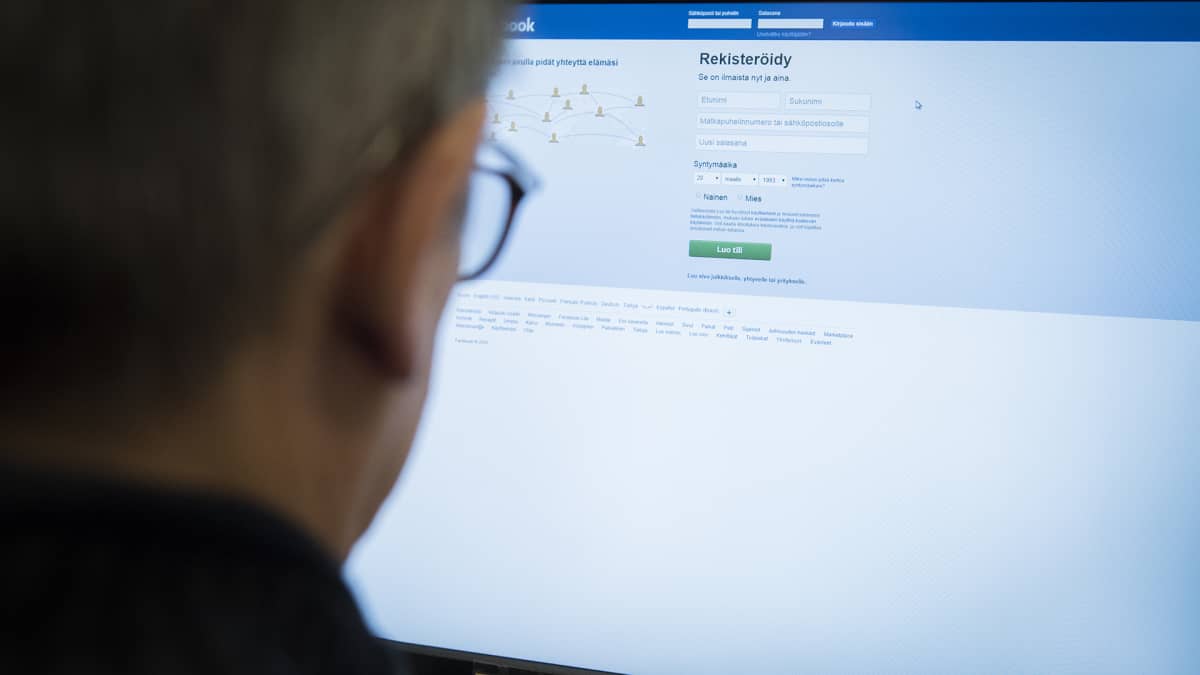 Mies tietokoneen ääressä kirjautumassa Facebookiin.