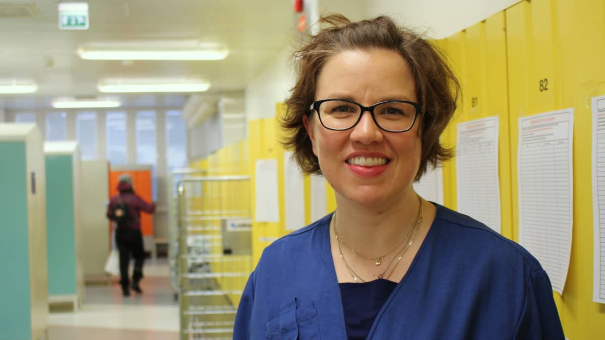 Sairaanhoitaja Riitta Mertanen sairaalan pukukaapeilla