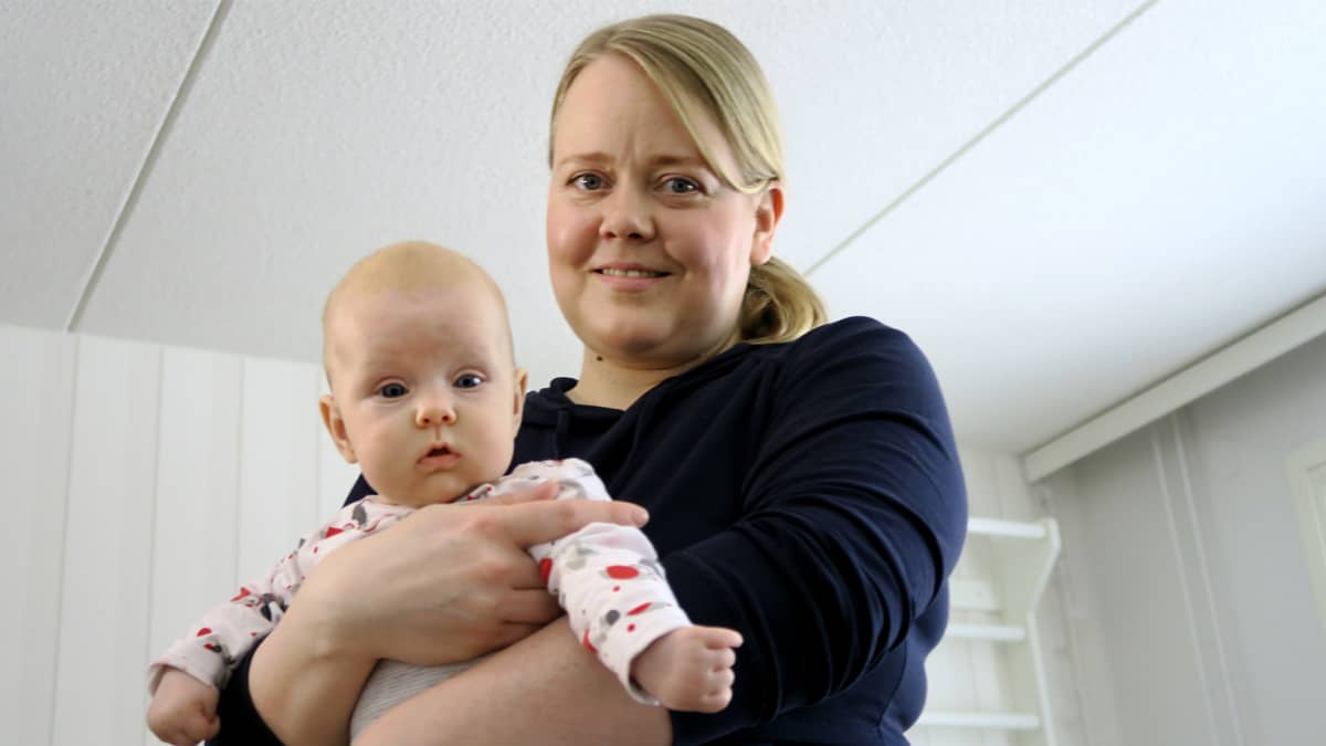 Äiti kuvattuna vauva sylissään.