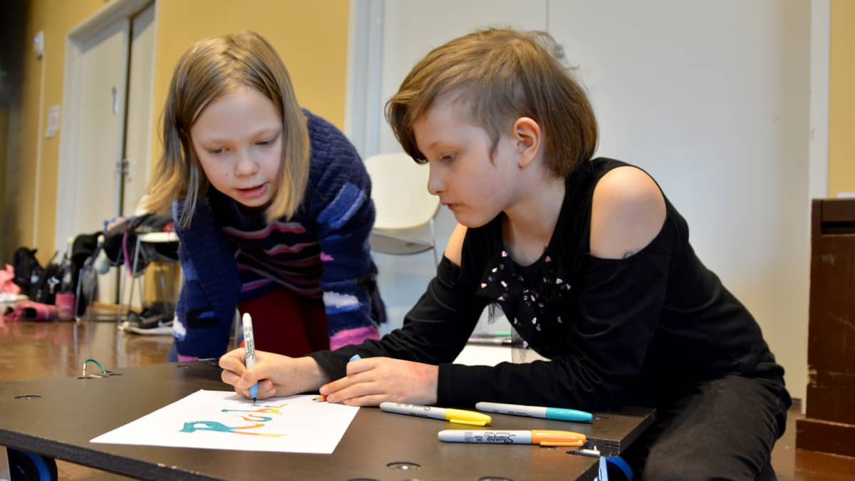 Koululaiset Isla Rikala ja Ottilia Masti luonnostelevat graffitia