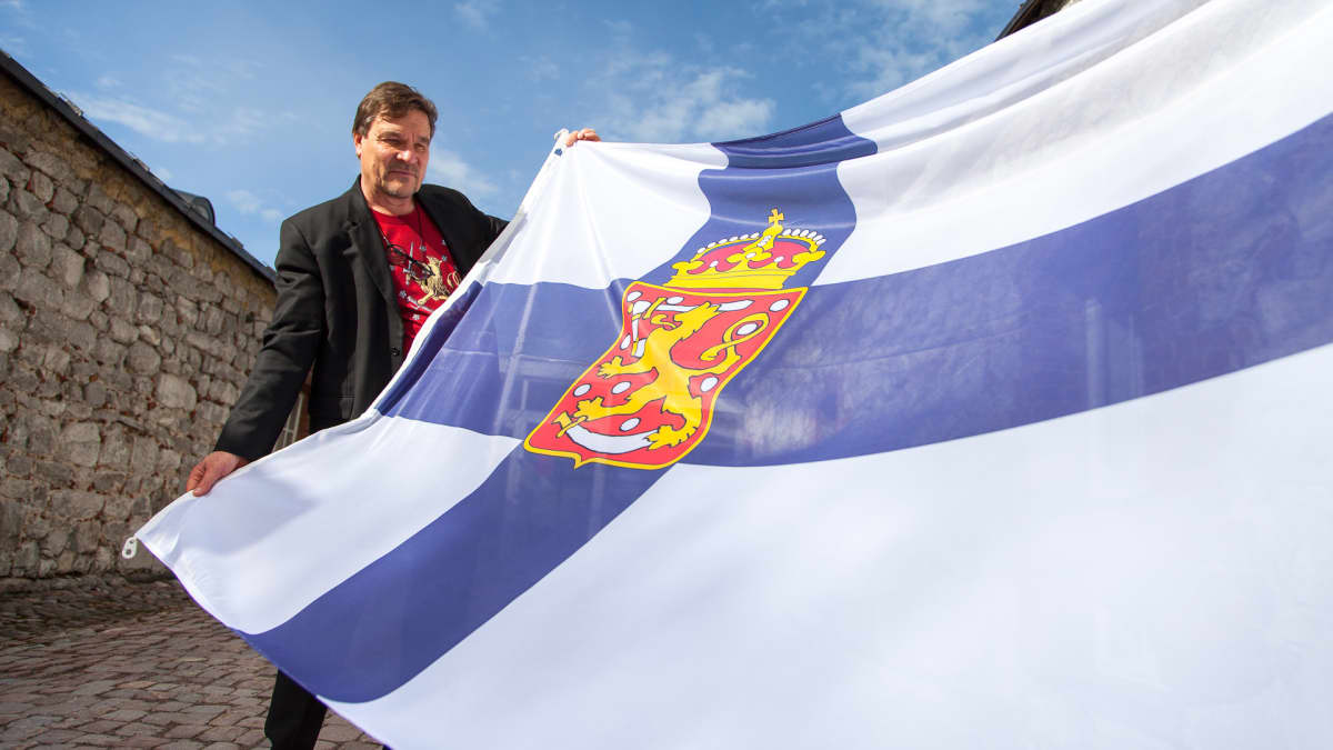 Kimmo Kiljunen pitelee ensimmäistä Suomen lippua