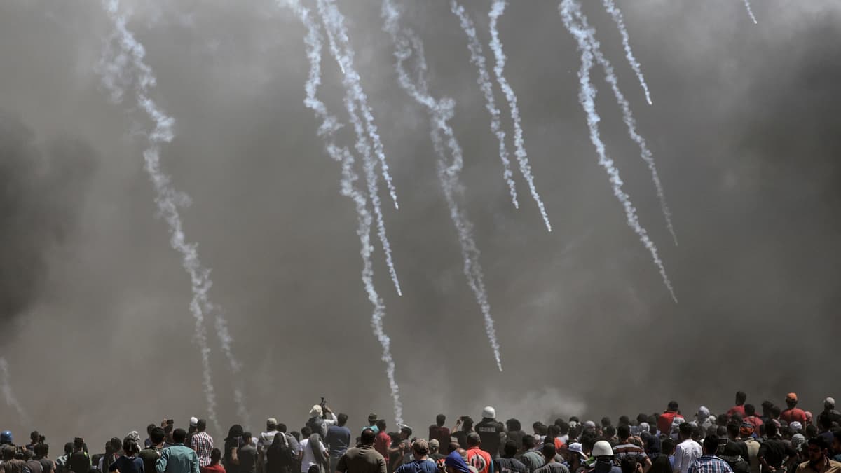 Palestiinalaismielenosoittajat juoksevat karkuun Israelin ampuessa kyynelkaasua Gazan ja Israelin rajalla.