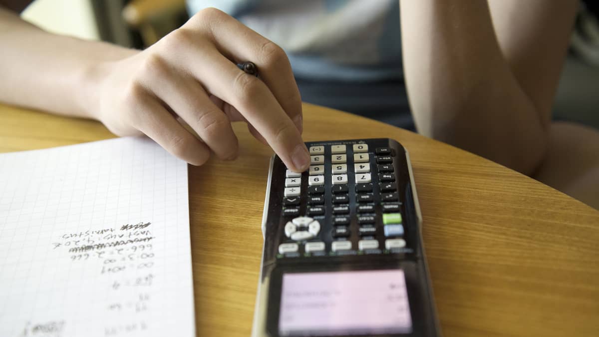 Nuori laskee matematiikan tehtäviä funktiolaskimella.