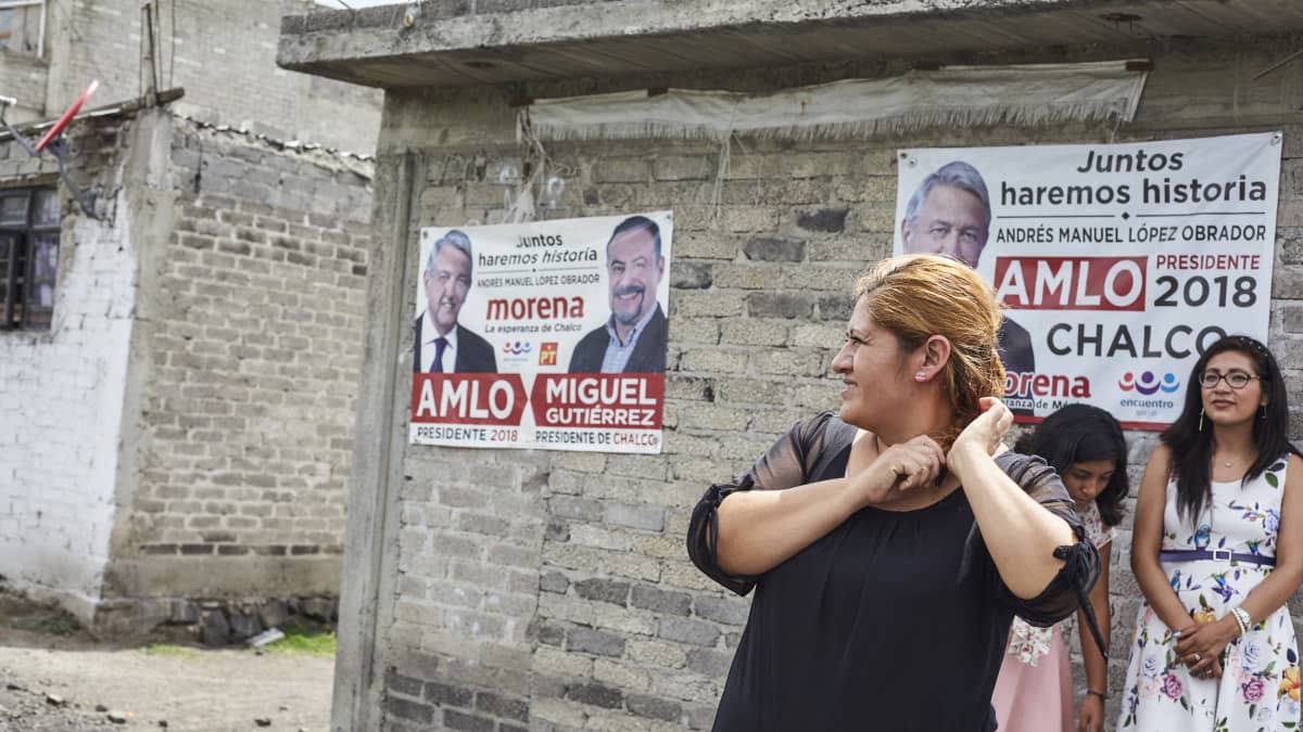 Marisol Vázquez Ramos äitinsä talon edustalla. San Juan Tezompan kylässä lähes jokaisen talon seinällä roikkuu Andrés Manuel López Obradorin kannatuksesta kertova mainos.