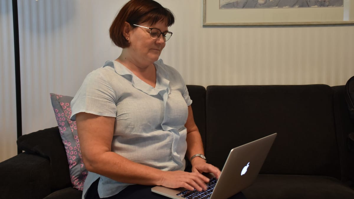 Päivi Heurlin kirjoittaa tietokoneella.