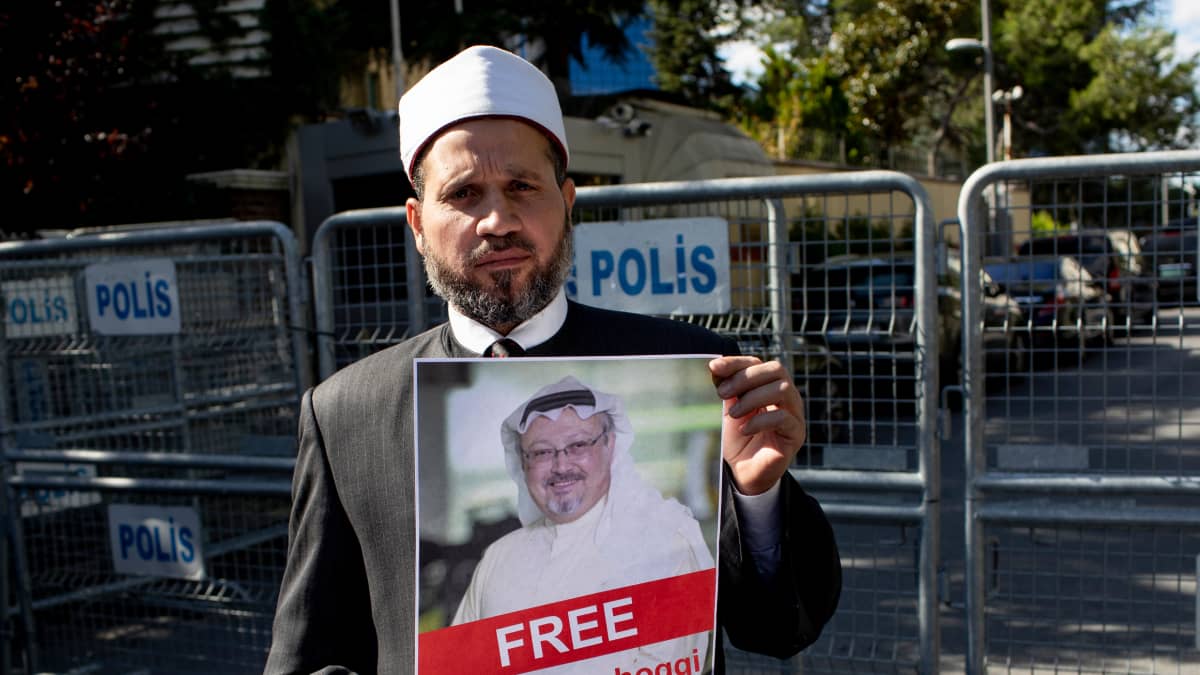 Protestoija pitää kädessään saudijournalisti Jamal Khashoggin kuvaa Saudi-Arabian konsulaatin edessä Istanbulissa 5.10.2018.
