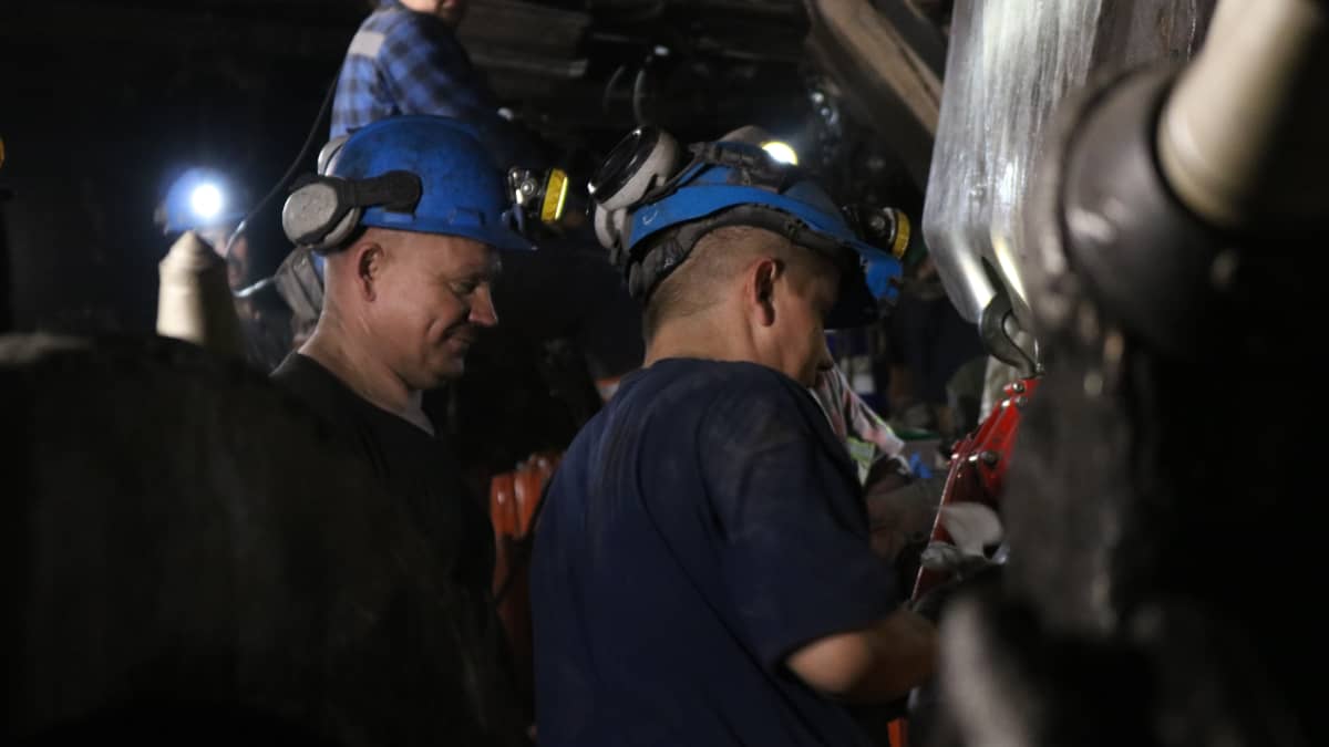 Bogdankan kaivosmiehet valmistelevat käyttökuntoon konetta, joka repii hiilen esiintymän seinästä.