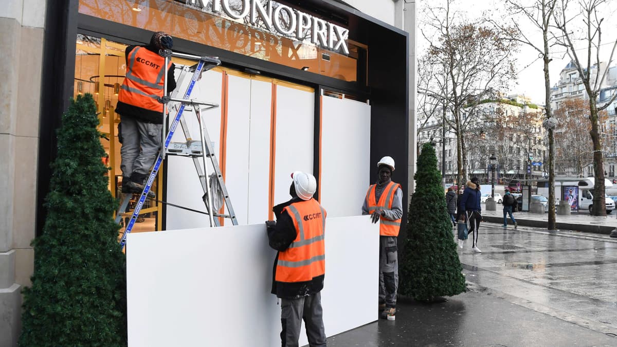 Työntekijät suojaavat näyteikkunoita Champs-Elyseellä perjantaina tulevan mielenosoituksen takia.