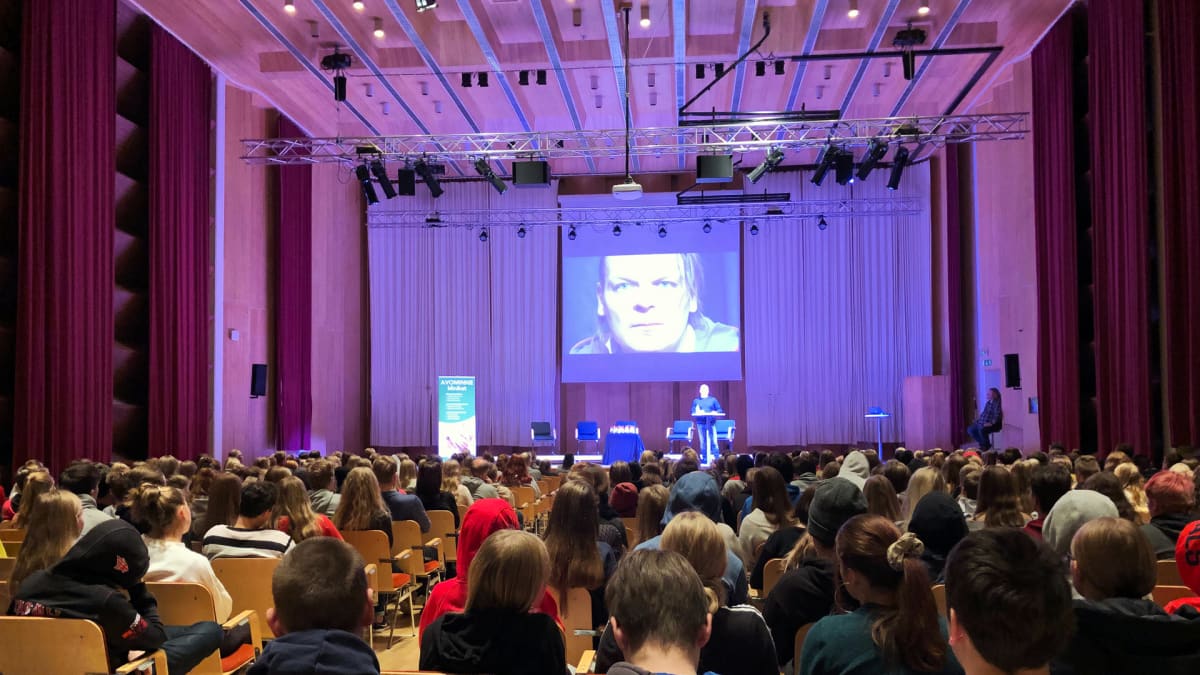 Kuvassa koululaisia kuuntelemassa huumevalistusta