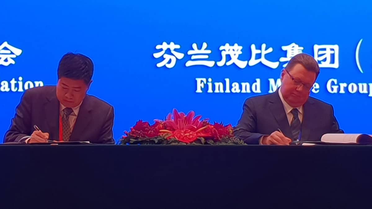 Mobie Groupin hallituksen puheenjohtaja Kari Vatanen allekirjoittaa koulutusvientisopimuksen pääsihteeri Yang Zijianin kanssa Kiinan 
kansojen hallissa pidetyssä konferenssissa.
