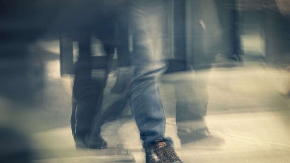 Nuori ihminen kävelee farkut ja kengät jalassaan.