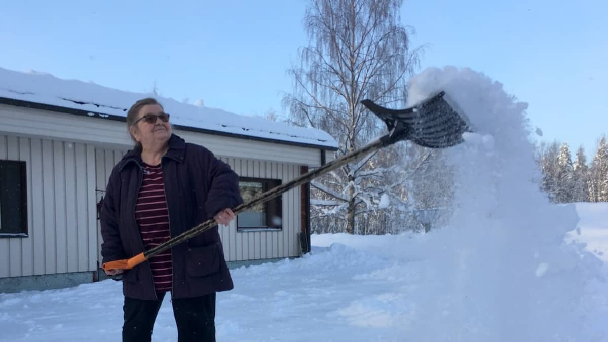 Eeva Korhonen pitää pihan omin käsin puhtaana.