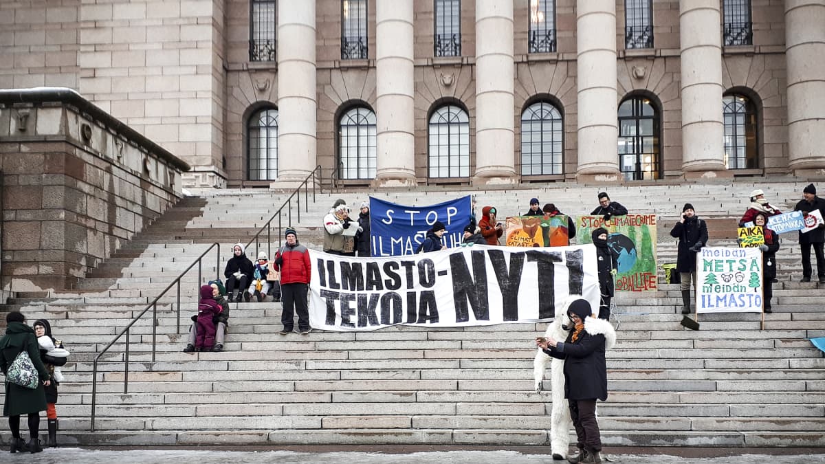 Mielenosoittajia Eduskuntatalon portailla perjantaiaamuna 8. helmikuuta.