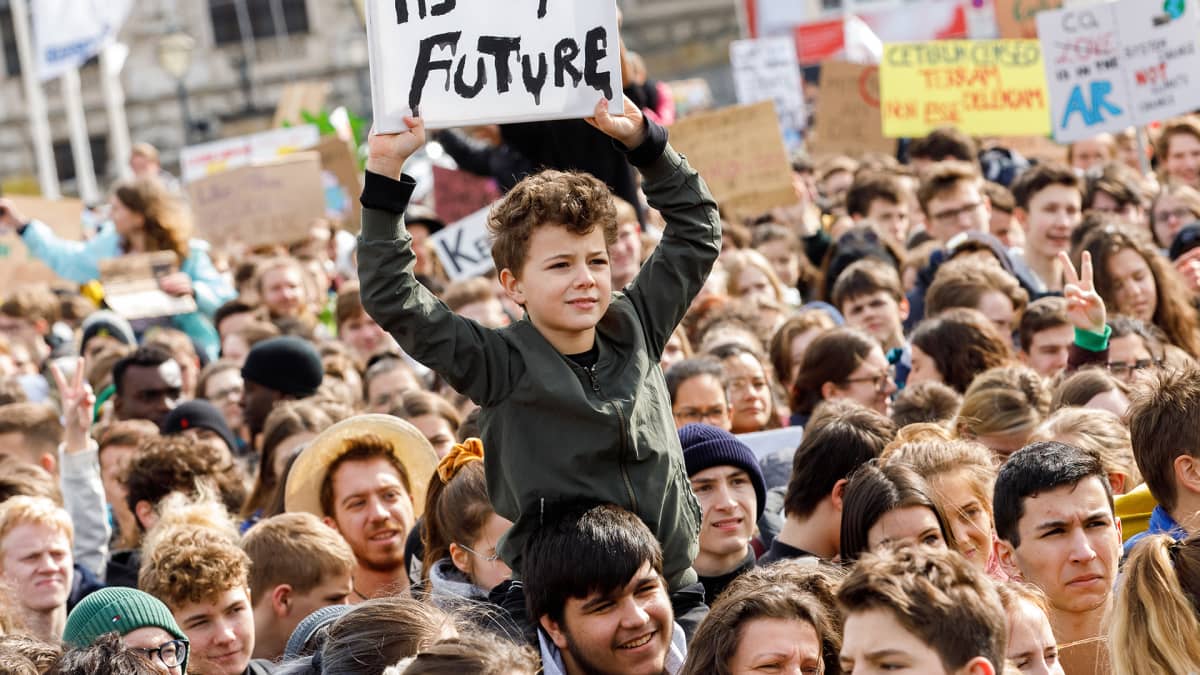 Poika, jonka kyltissä lukee "It's my future"