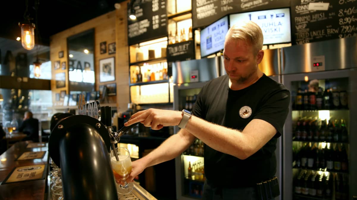 Kampin Teerenpelin ravintolapäällikkö Miika Korpela kaataa olutta hanasta.