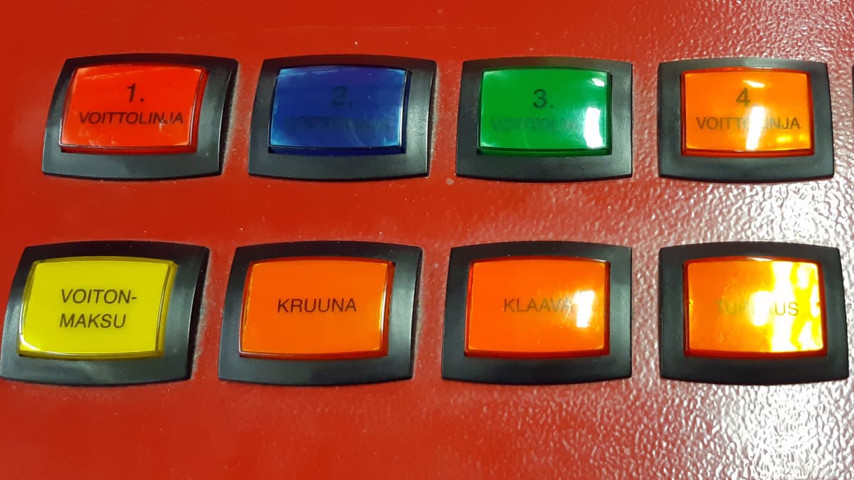 Rahapeliautomaatin värikkäitä nappuloita rivissä. 
