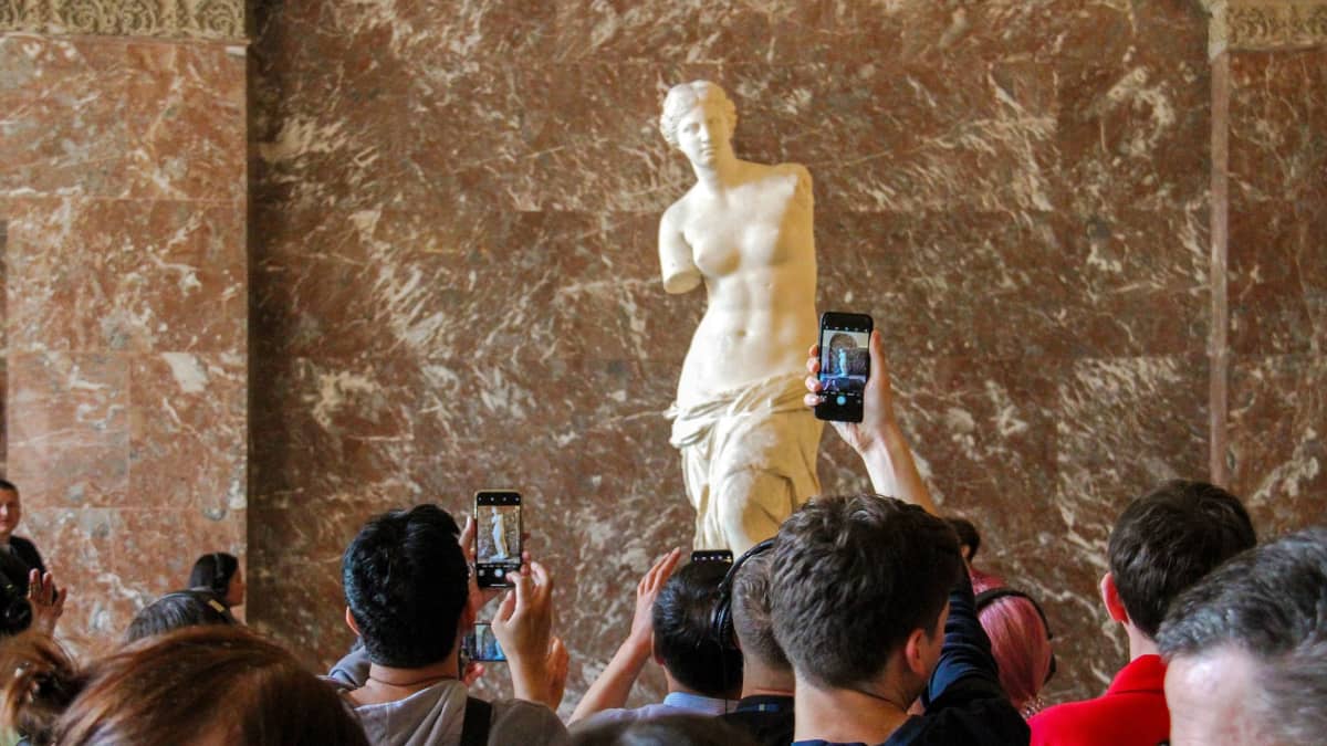 Turisteja katsomassa Milon Venus -veistosta Louvressa.