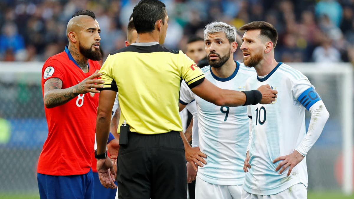 Chilen Arturo Vidal (vas.) ja Argentiinan Lionel Messi tuomaripuhuttelussa. 