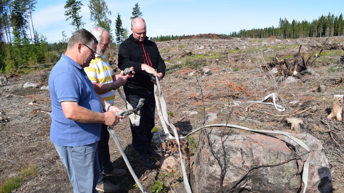 Hannu Raunela, Jarkko Ruohola ja Kai Saarinen katsovat palopaikalta löytynyttä sammutusletkua.