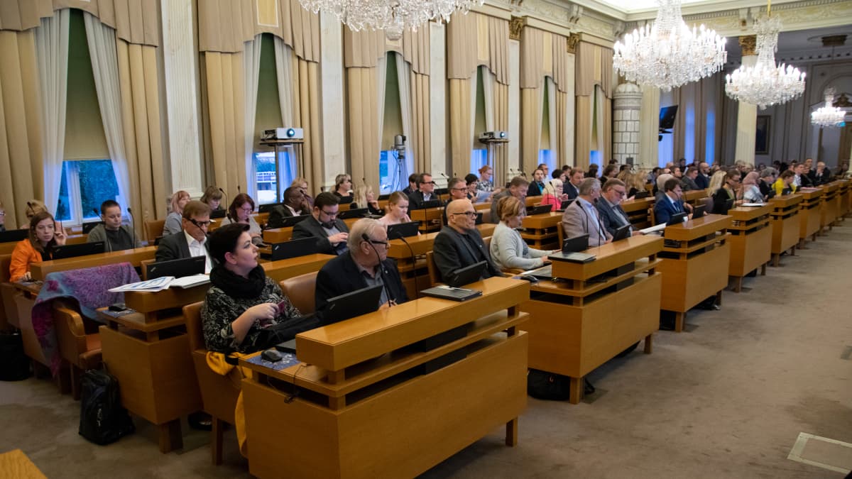 Turun kaupunginvaltuuston kokoussali. Valtuutetut istuvat pöytiensä ääressä.