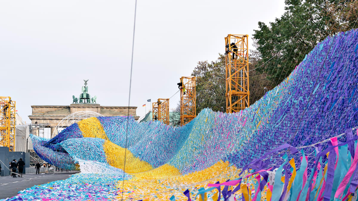 Yhdysvaltaisen taiteilijan, Patrick Shearnin, 'Visions in Motion' -installaatio Saksan Berliinissä. Se sijaitsee hyvin lähellä kuvassa näkyvää Brandenburgin porttia ja liittyy muurinmurtumisen 30-vuotisjuhlallisuuksiin.