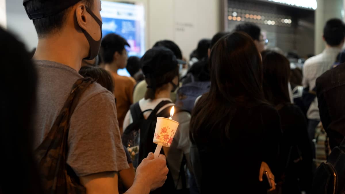 Tuhannet kynttiläkulkueeseen osallistuneet surivat perjantaina kuollutta opiskelijaa Hongkongissa.