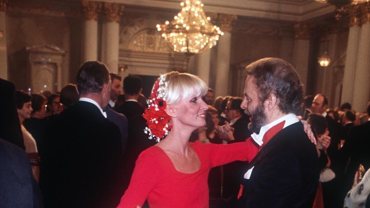 Vuoden 1977 vastaanotolla Marjatta Sarpaneva ihastutti veistoksellisessa punaisessa puvussa puolisonsa Timo Sarpanevan rinnalla.