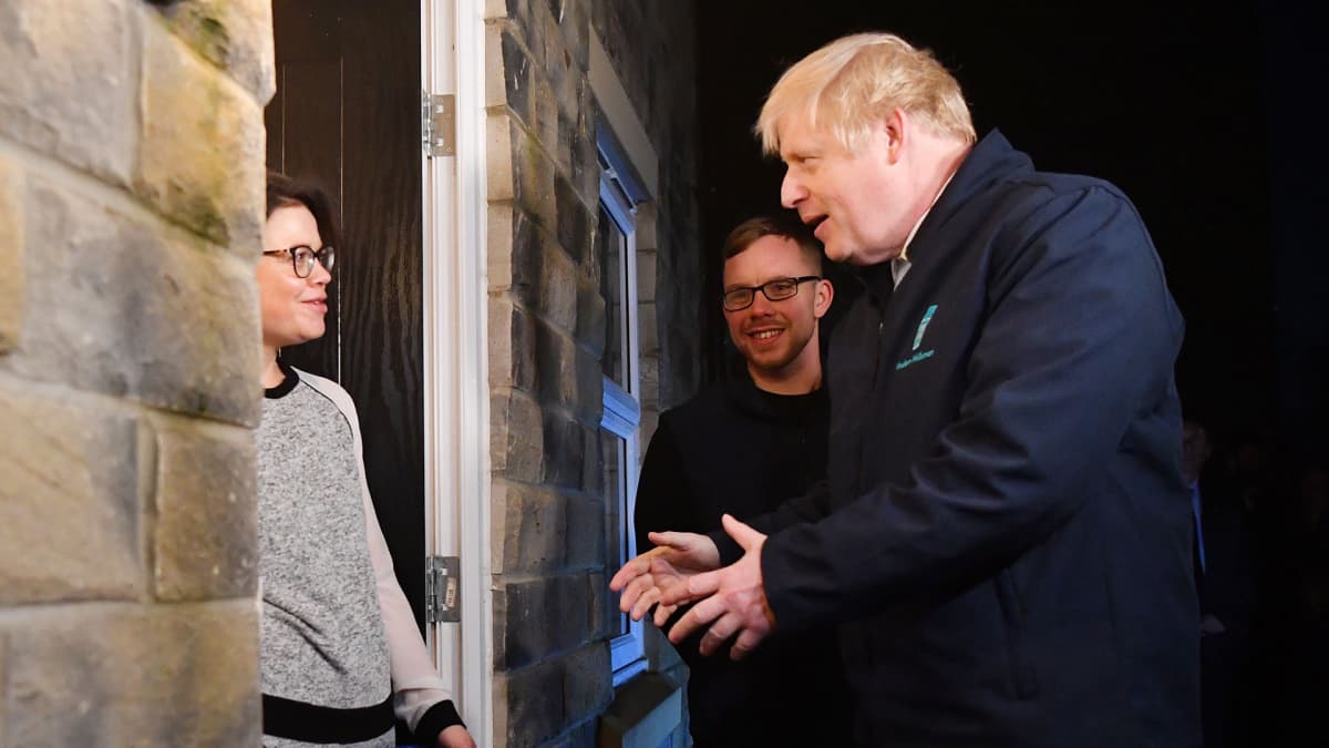 Britannian pääministeri Boris Johnson kotiinkuljettaa maitoa Debbie  Monaghanille Guiseleyssä, Leedsissä 11. joulukuuta