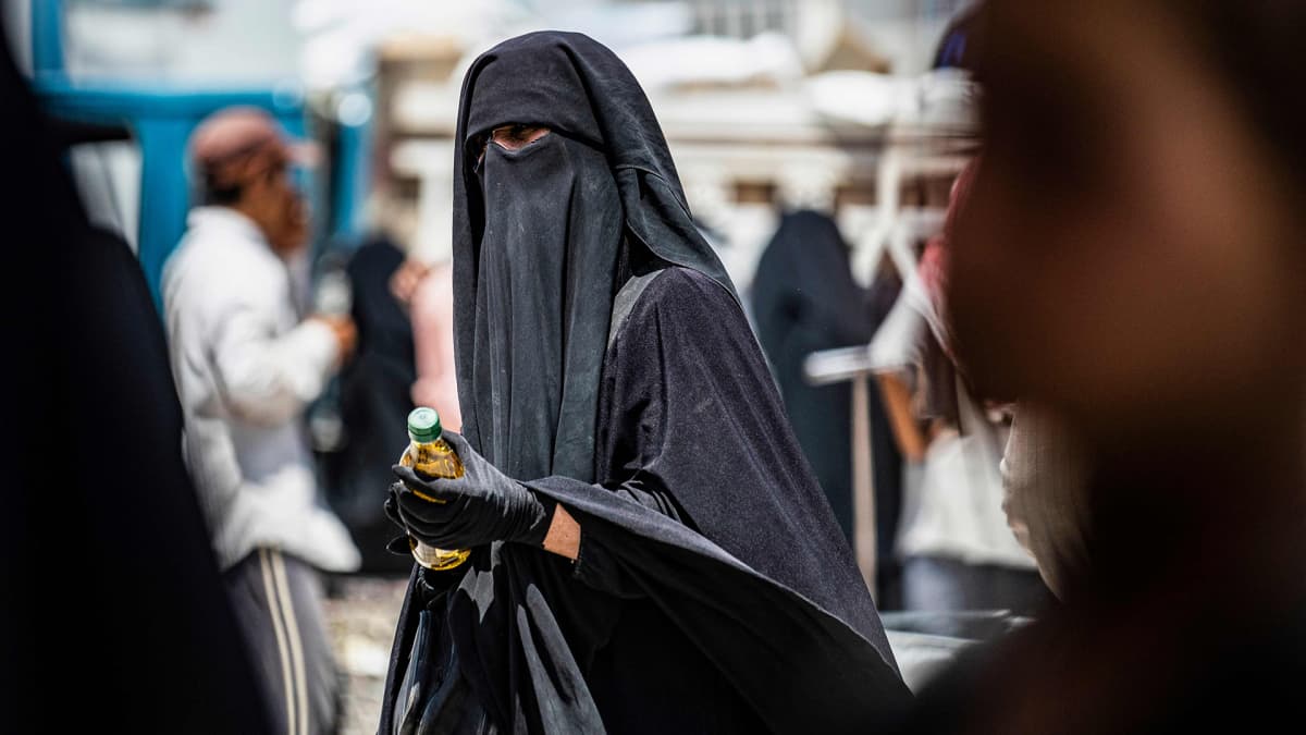 Niqabiin pukeutunut nainen sai ruoka-apua al-Holin leirillä Syyriassa 22. heinäkuuta. 