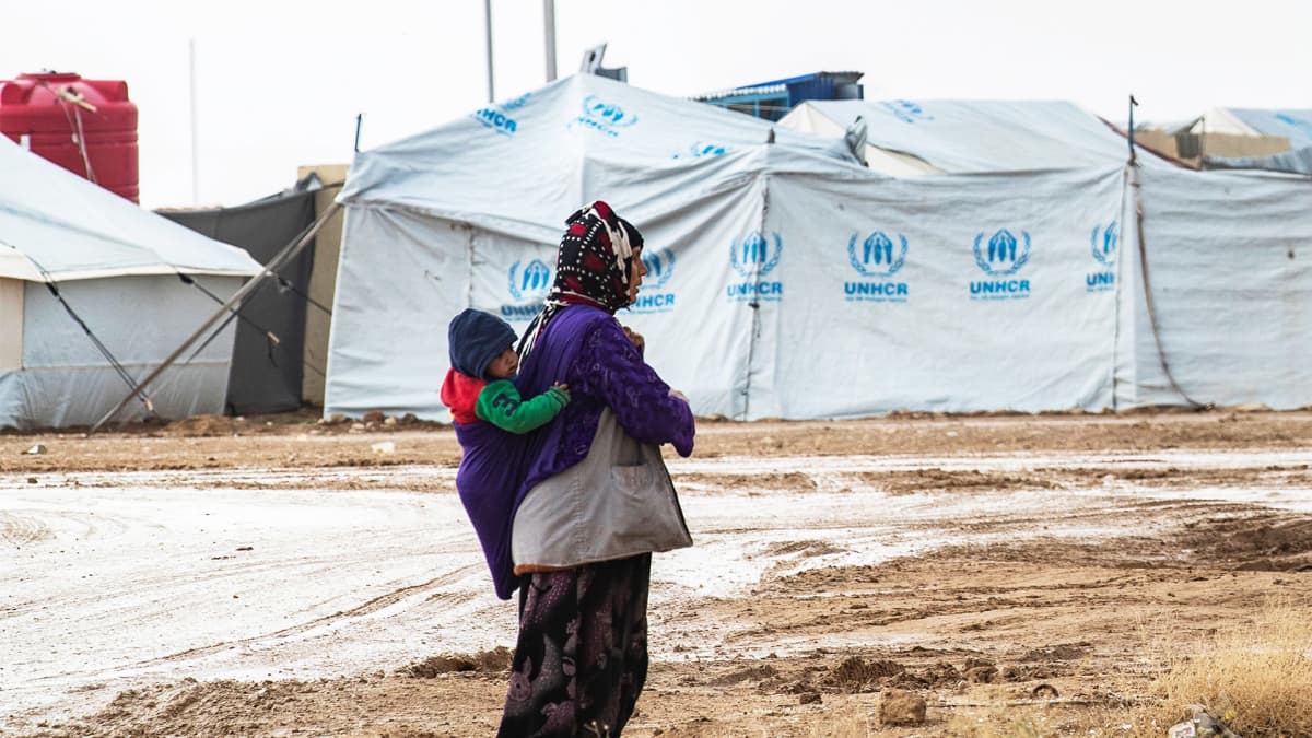 Nainen kantaa lasta selässään al-Holin leirillä.