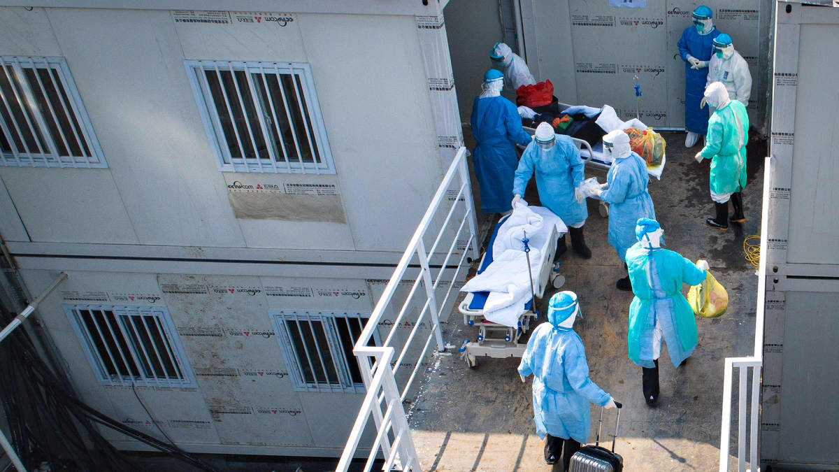 Koronaviruspotilasta siirretään sairaalan sisään Kiinan Wuhanissa 4. helmikuuta 2020.