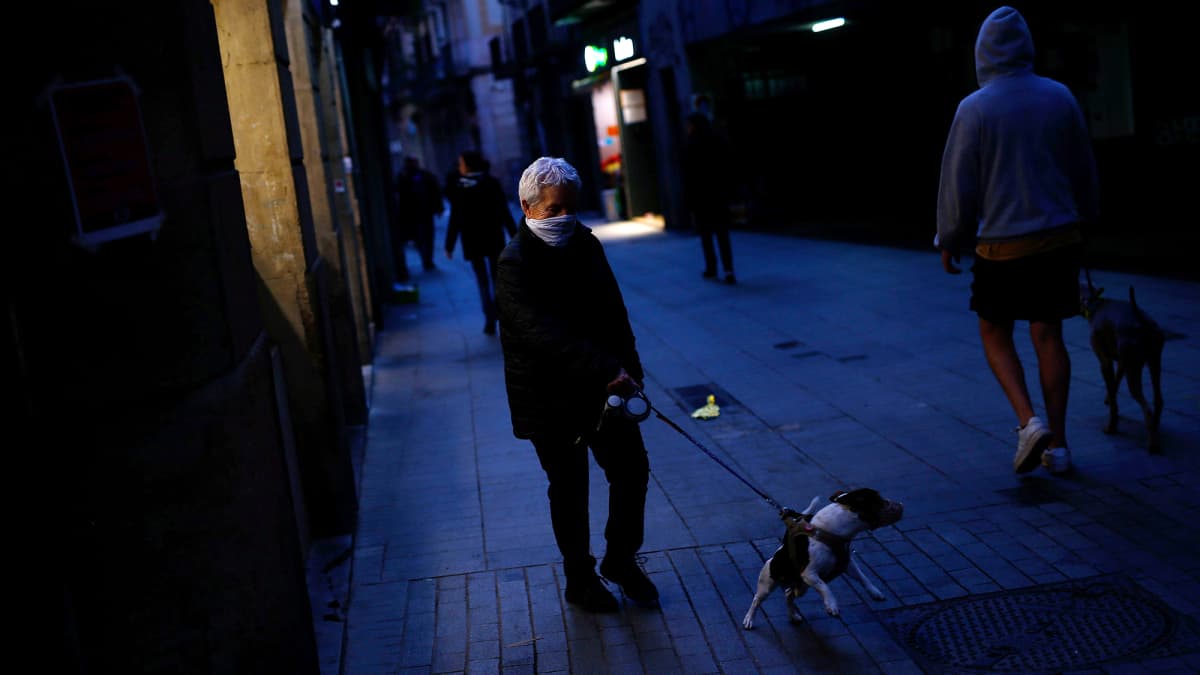 Kaksi koiranulkoiluttajaa ohittavat toisensa kadulla Barcelonassa.