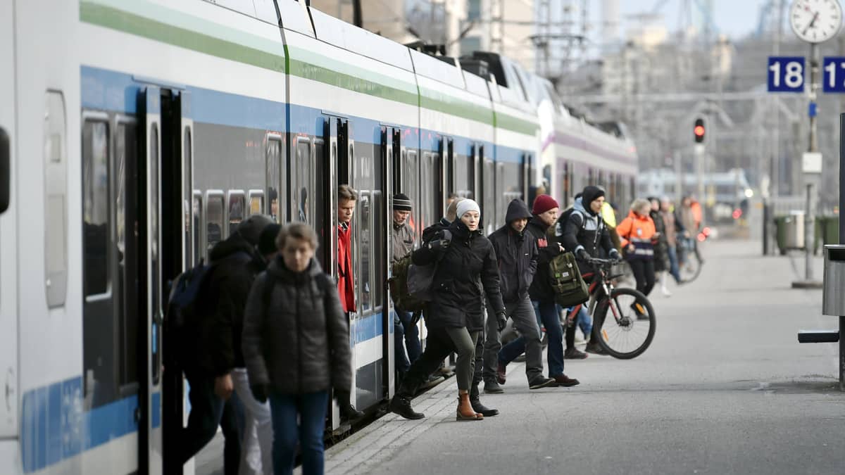 Junamatkustajia nousee lähijunasta Helsingin Päärautatieasemalle torstaiaamuna 26. maaliskuuta