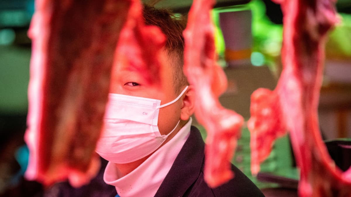 Lihakauppias oli varustautunut suojamaskilla ruokatorilla Guangzhoussa helmikuussa. 