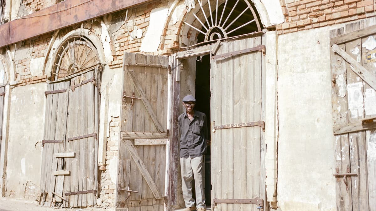 Souleymane Seye seisoo kaksikerroksisen talon edustalla.
