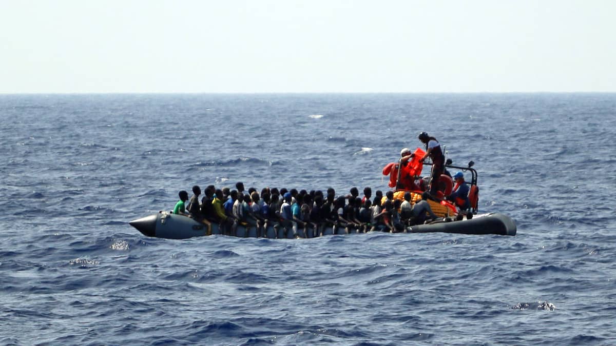 Kuvassa on vene täynnä siirtolaisia Välimerellä.