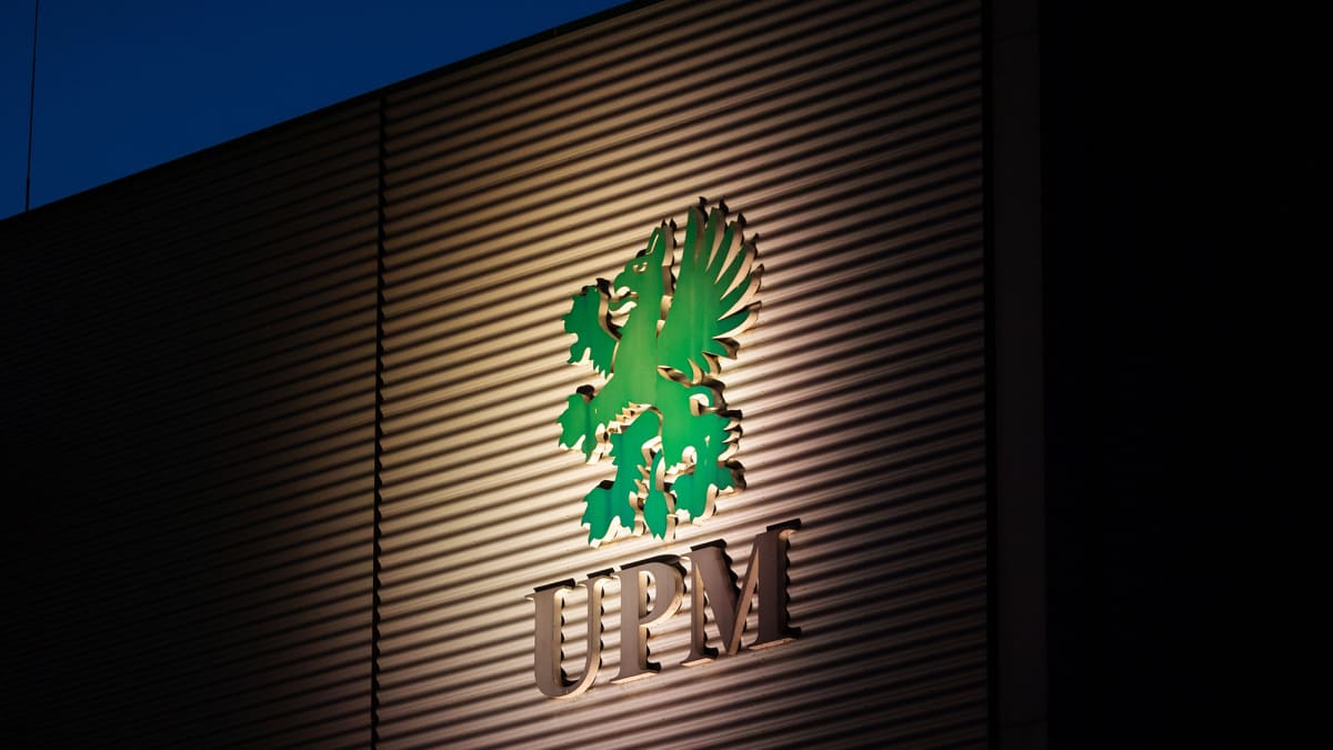 Kuvassa on metsäyhtiö UPM:n kyltti seinällä.