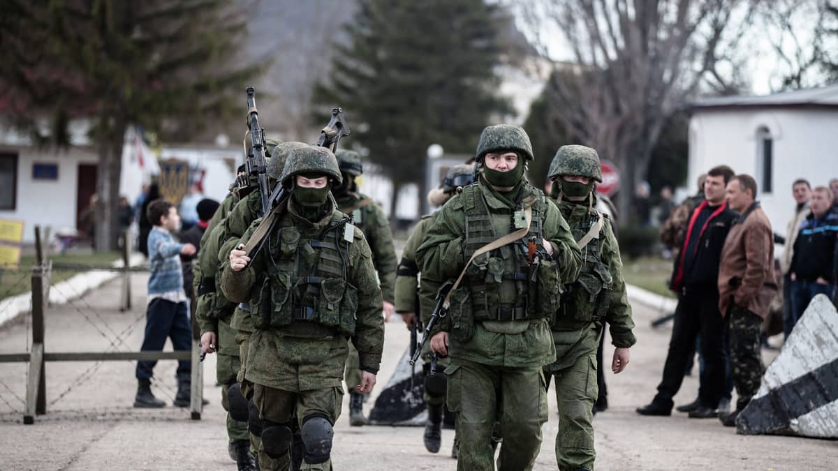 Taisteluvarustuksessa olevat, venäläisiksi epäillyt sotilaat marssivat Simferopolissa Krimillä vuonna 2014.