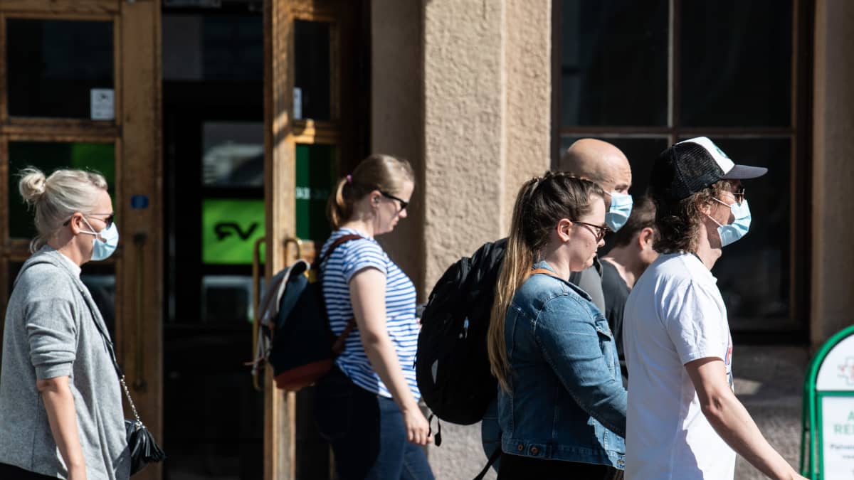 Ihmisiä kasvomaskit päällä Helsingin rautatieasemalla 