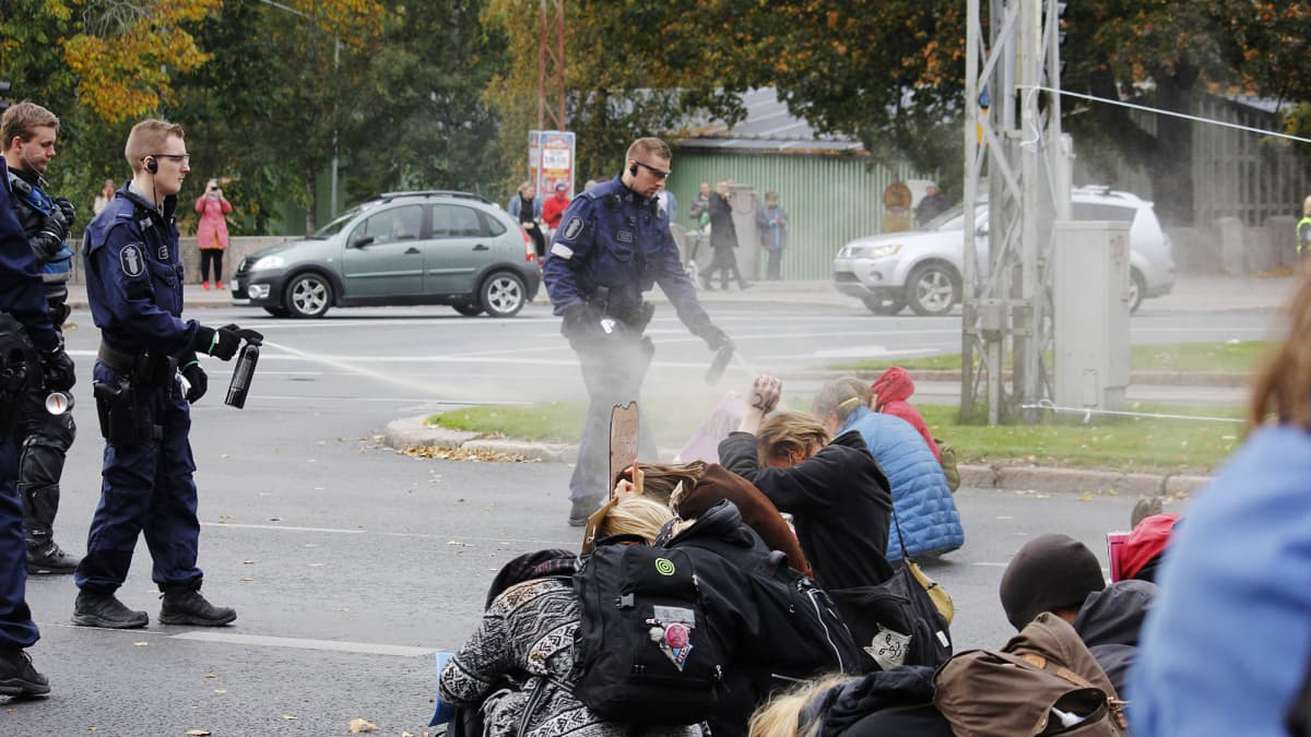 Kuvassa poliisi kaasuttaa mielenosoittajia Helsingissä.