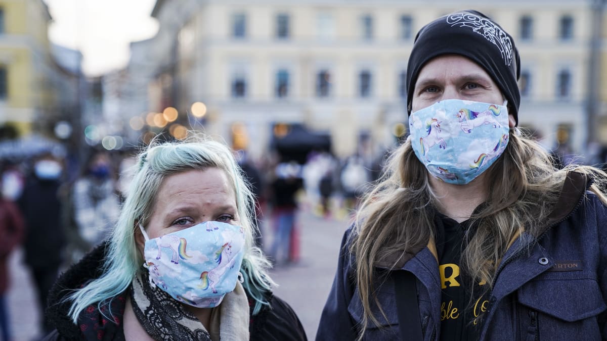 Sini Kipinä ja Antti Kotinurmi poseerasivat maskit kasvoillaan Senaatintorilla.