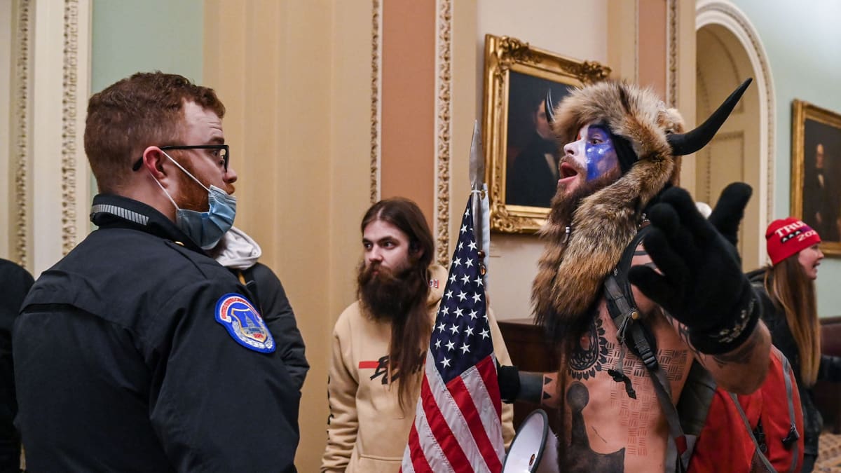 Mielenosoittaja puhuu vartijalle Yhdysvaltain kongressitalossa Washington DC:ssä.