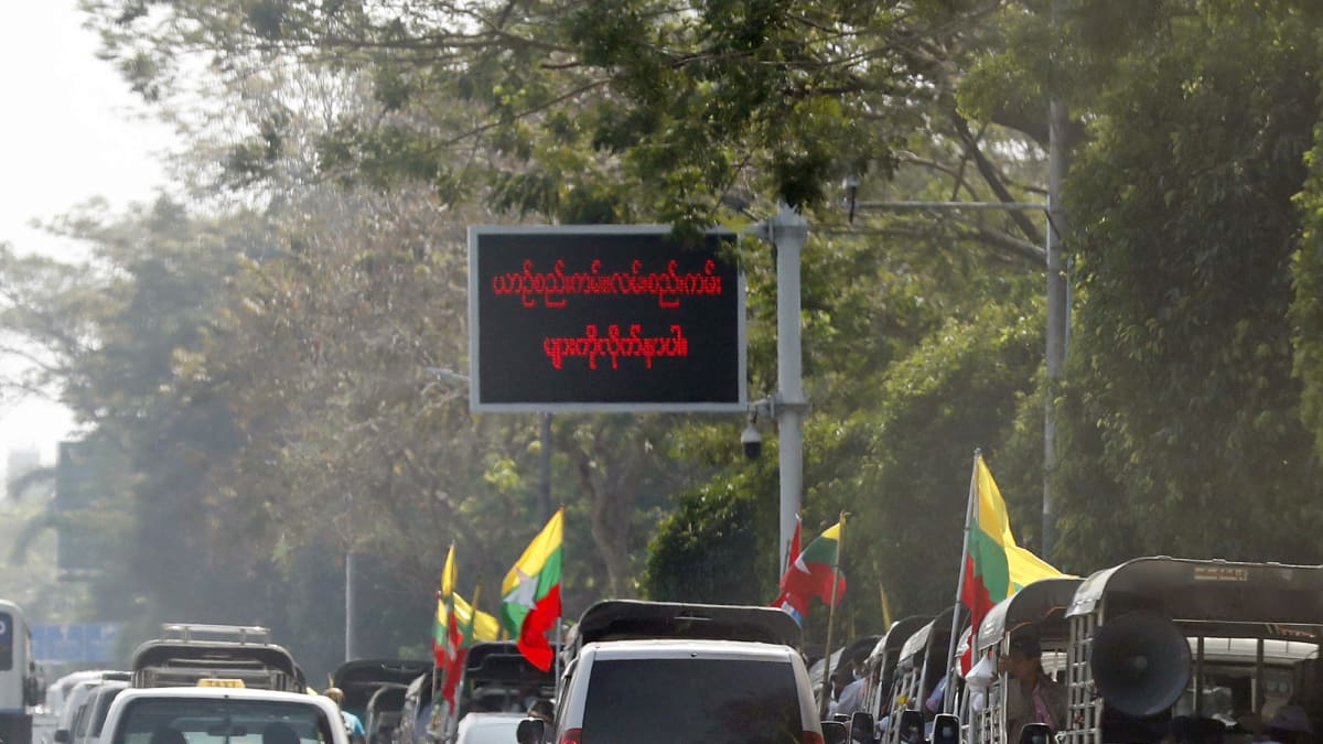 Myanmarin armeijan kannattajat juhlivat heiluttelemalla lippuja autojen ikkunoista.