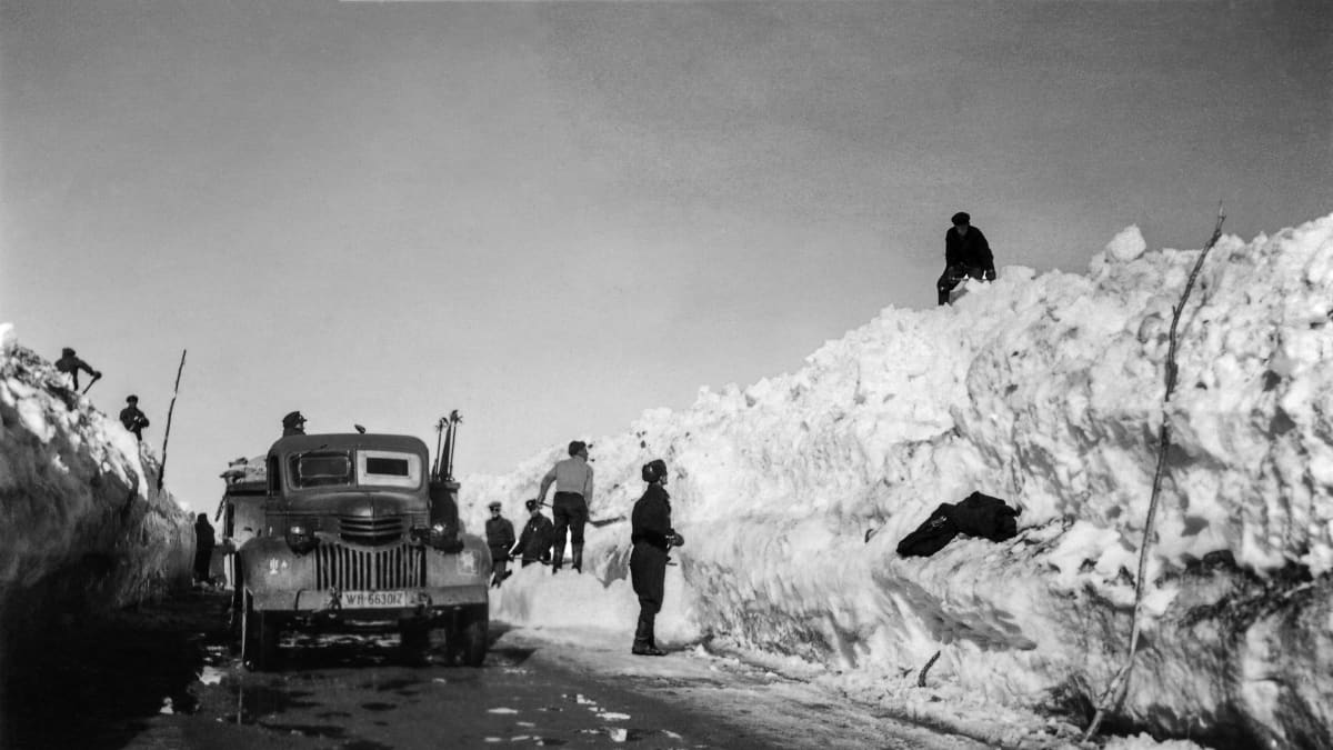 Miehiä lapioimassa lunta Jäämerentieltä. Tiellä on kuorma-auto. Petsamo 1942 tai aikaisemmin.